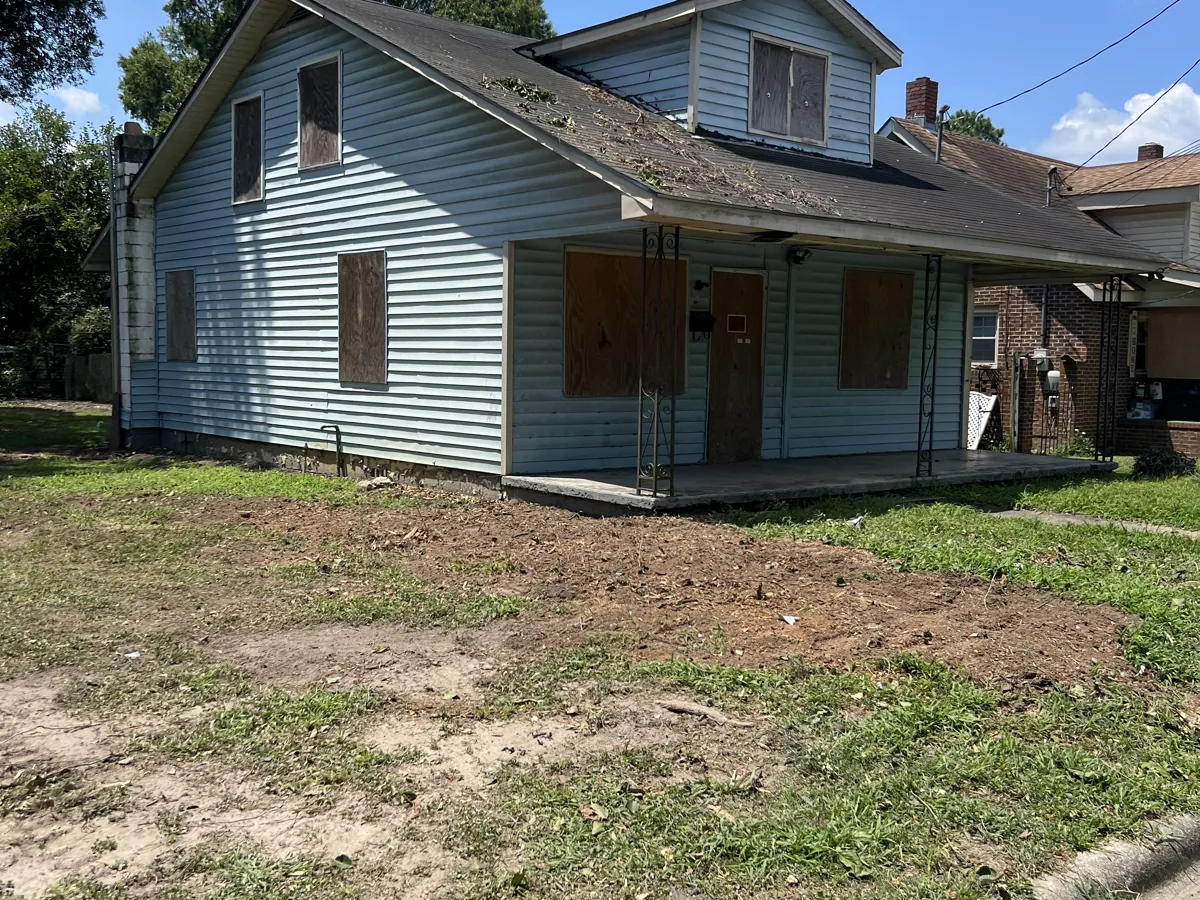 Cleared residential lot in front of an older home in Greenville, NC after tree and brush removal